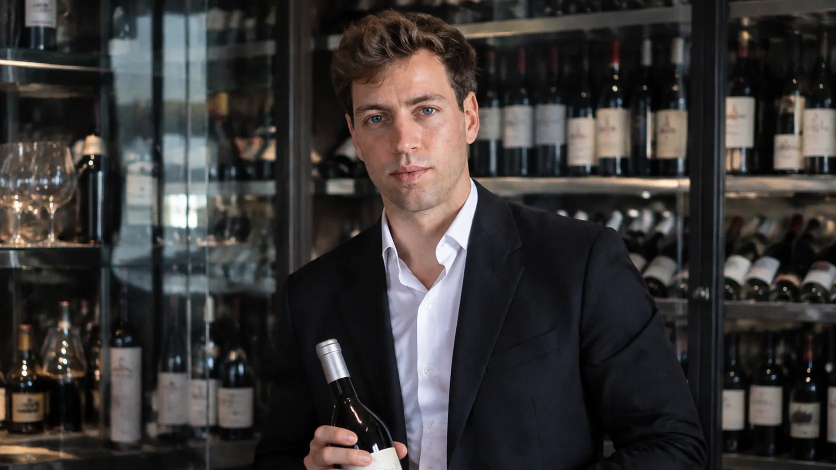 Responsable de La Llotja en la bodega del restaurante, con una botella de vino