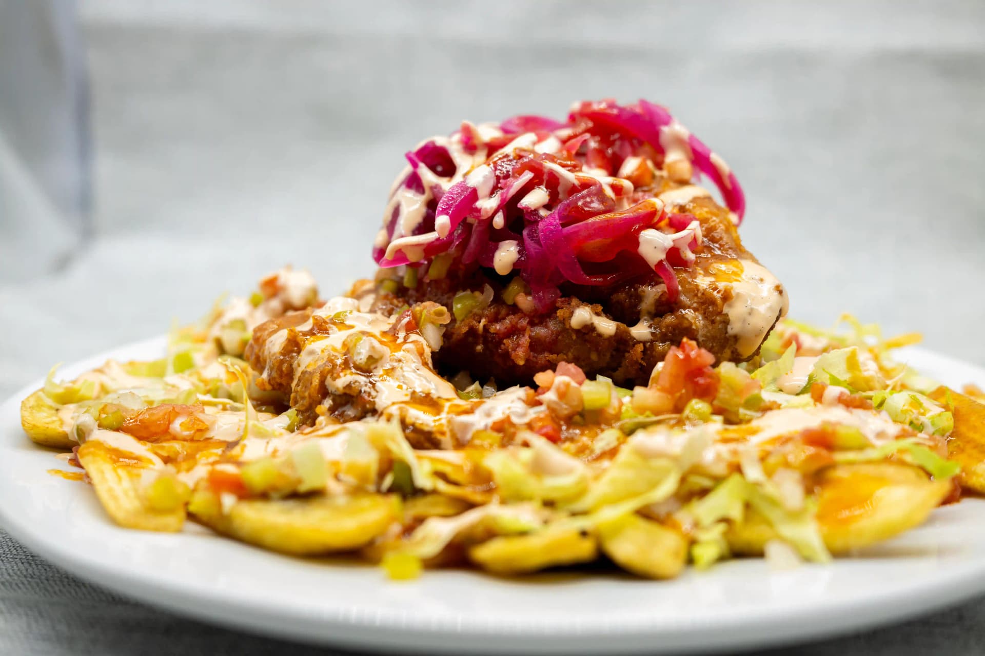 de plátano frito con carne repollo y cebolla encurtida plato típico hondureño servido en restaurante latino en Figueres