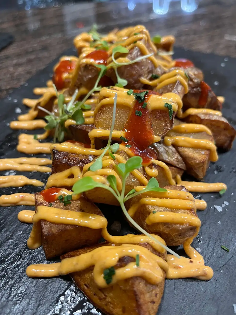 Patatas bravas con alioli y salsa picante en Cal Tete, restaurante mediterráneo en Sant Martí, Barcelona. Perfectas para disfrutar en el menú del día o como tapa.