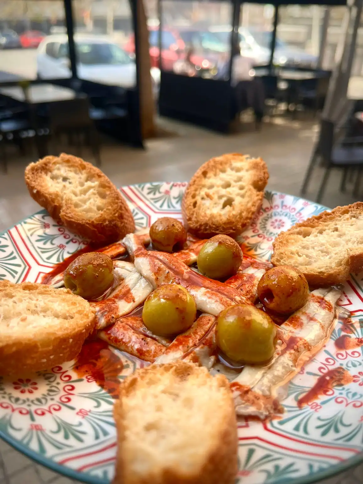 Anchoas con aceitunas y pan crujiente en Cal Tete, restaurante mediterráneo en Sant Martí, Barcelona. Ideal para disfrutar de tapas variadas cerca de Poblenou.