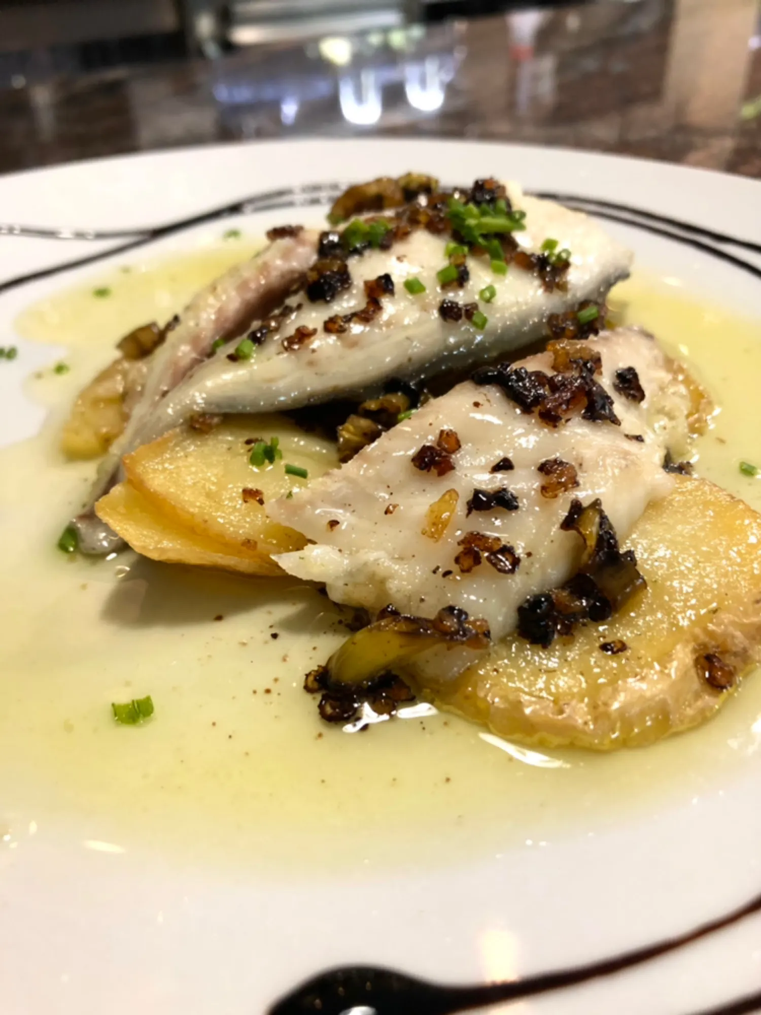 Merluza al horno con patatas en Cal Tete, restaurante mediterráneo en Sant Martí, Barcelona. Disfruta de este plato en nuestro menú del día.