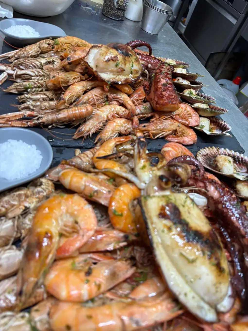 Parrillada de mariscos en Pulpería Arrocería el Poal, Vinaròs, destacando el pulpo a la brasa y variedad de mariscos frescos.