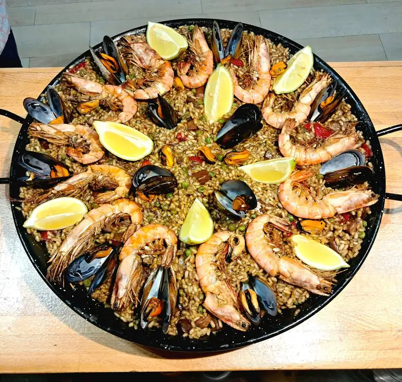 Paella de marisc amb gambes, musclos i llimona servida al Restaurant Samuga, cuina mediterrània a Sant Llorenç de la Muga (Girona)