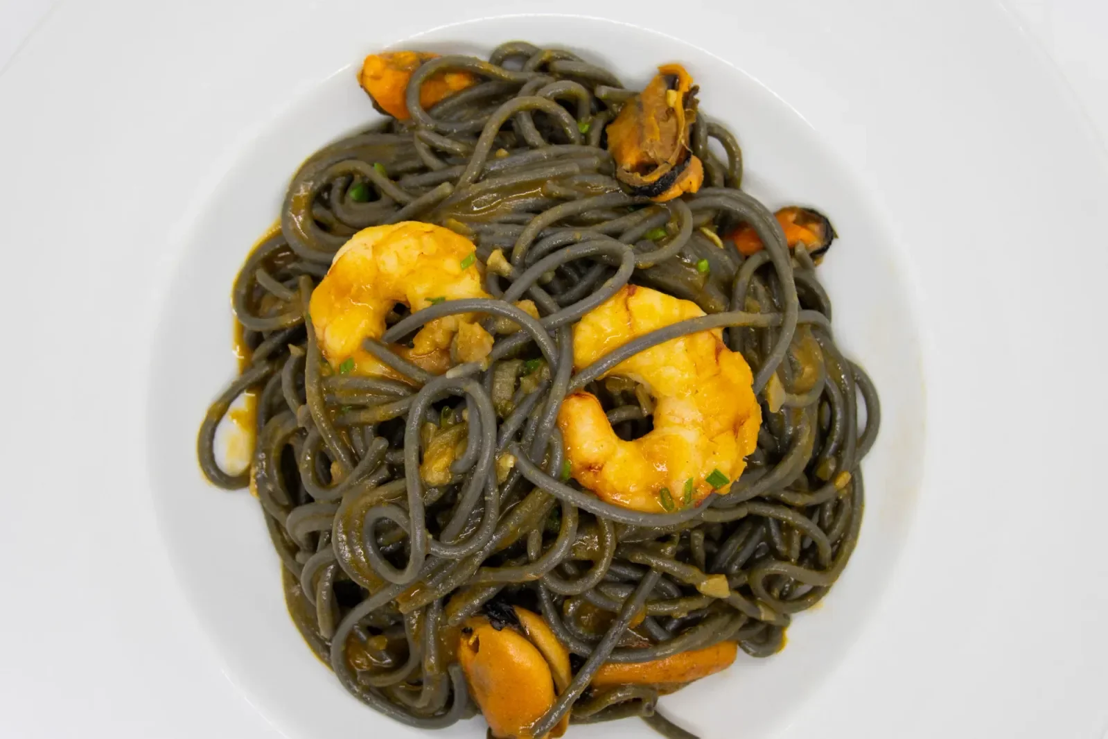 Espaguetis negros con mariscos en Agumas, restaurante de cocina mediterránea en Albanyà, Girona