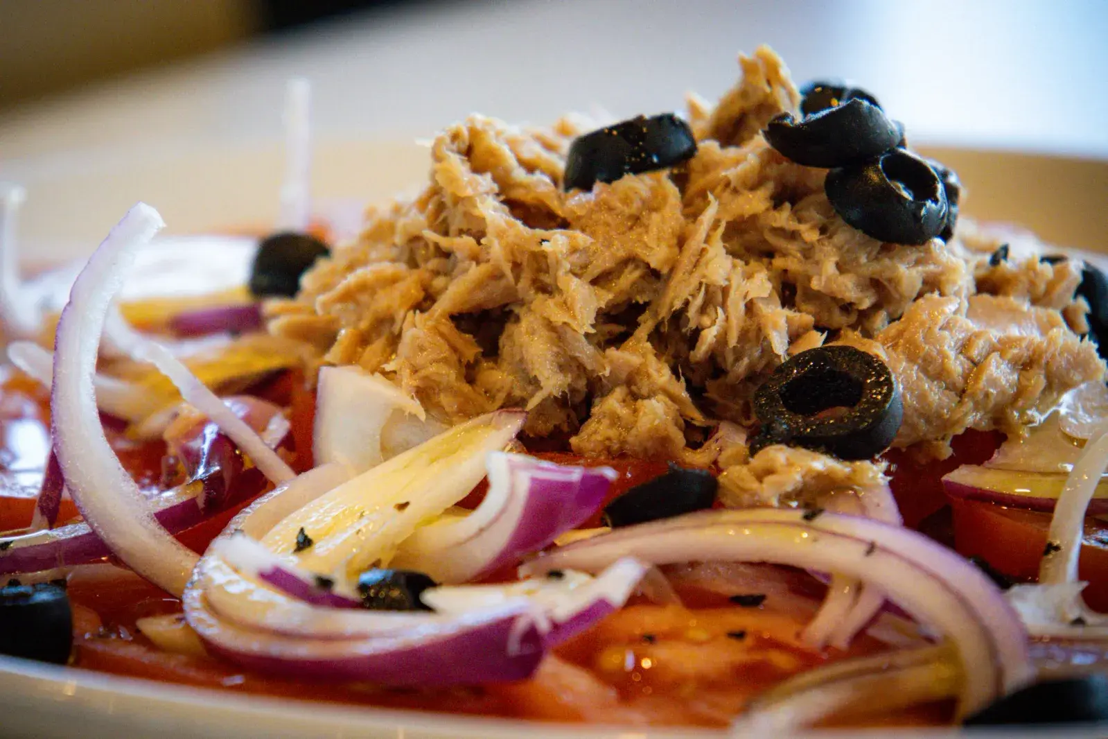 Ensalada de atún con cebolla roja y aceitunas negras en Agumas, restaurante de cocina mediterránea en Albanyà, Girona.