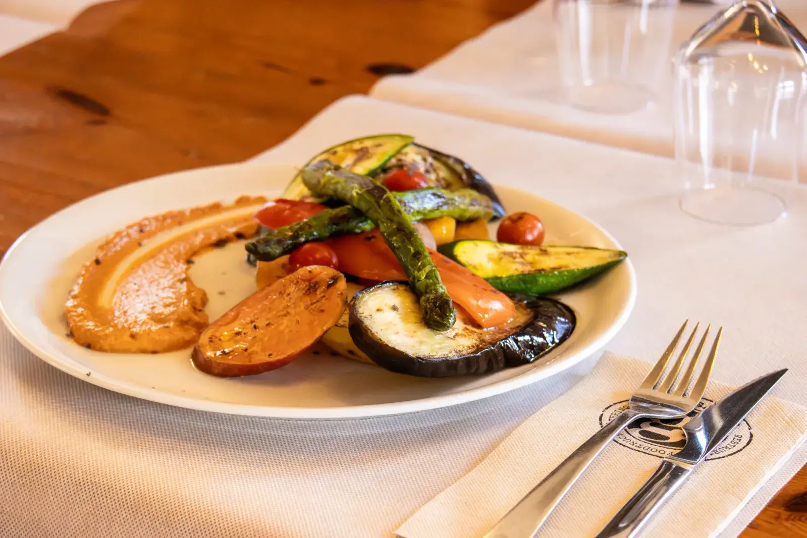 Verduras asadas con hummus en Agumas, restaurante de cocina mediterránea en Albanyà, Girona. Ideal para disfrutar en un entorno natural.