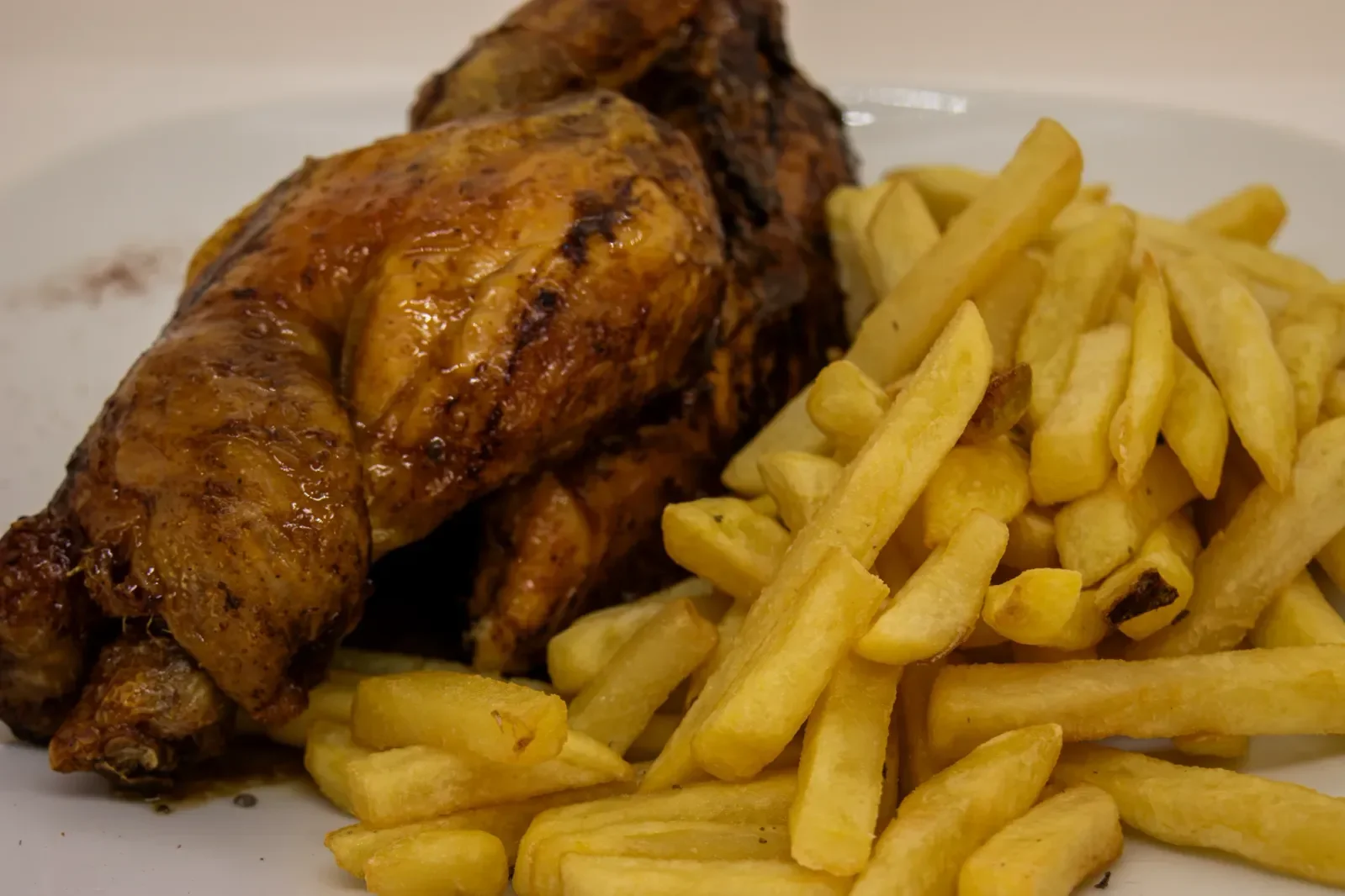 Pollo asado con patatas fritas en Agumas, restaurante de cocina mediterránea en Albanyà, Girona. Ideal para disfrutar en el corazón de la Alta Garrotxa.