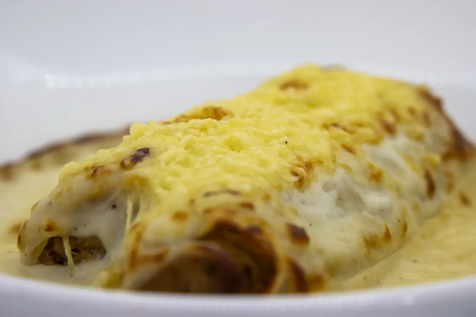 Canelones gratinados con bechamel en Agumas, restaurante de cocina mediterránea en Albanyà, Girona.