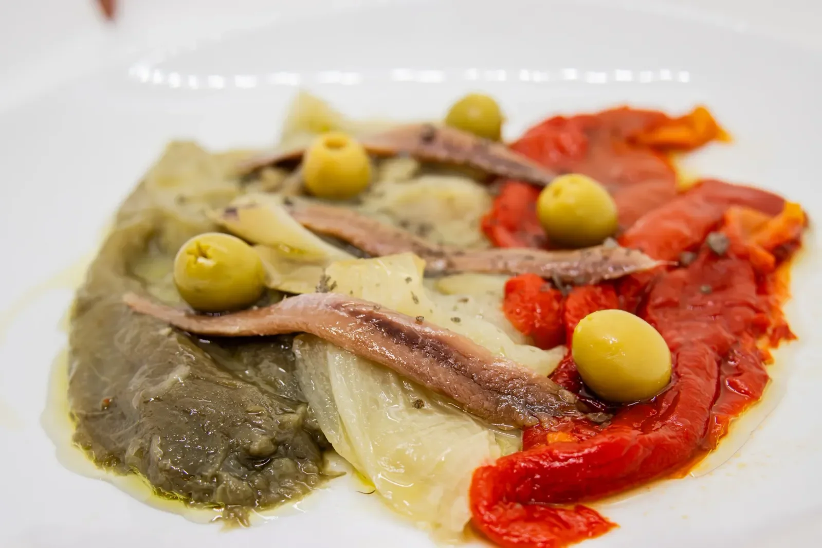 Escalivada con anchoas en Agumas, restaurante de cocina mediterránea en Albanyà, Girona. Disfruta de este plato tradicional en un entorno natural excepcional.