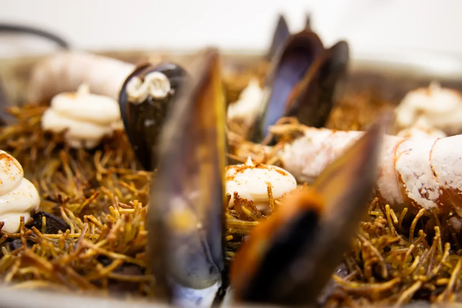 Fideuá de mariscos en Agumas, restaurante de cocina mediterránea en Albanyà, Girona. Disfruta de este plato en un entorno natural excepcional.