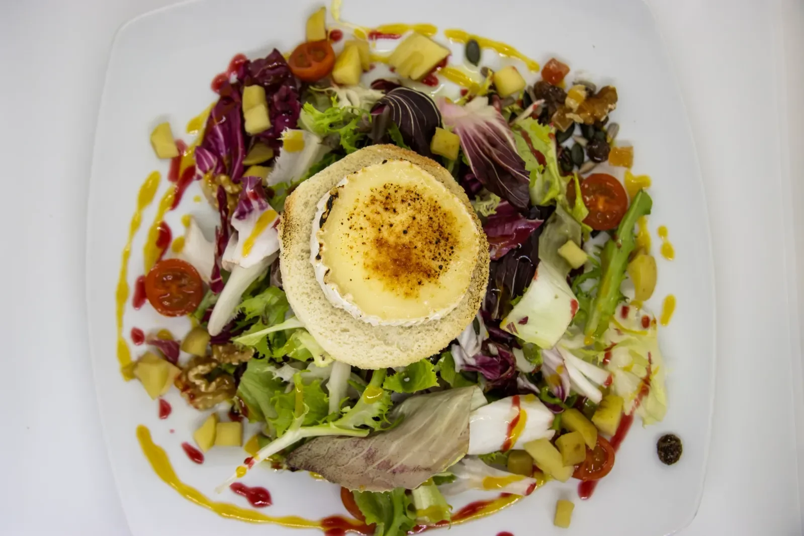 Ensalada de queso de cabra en Agumas, restaurante de cocina mediterránea en Albanyà, Girona. Ideal para disfrutar en un entorno natural.