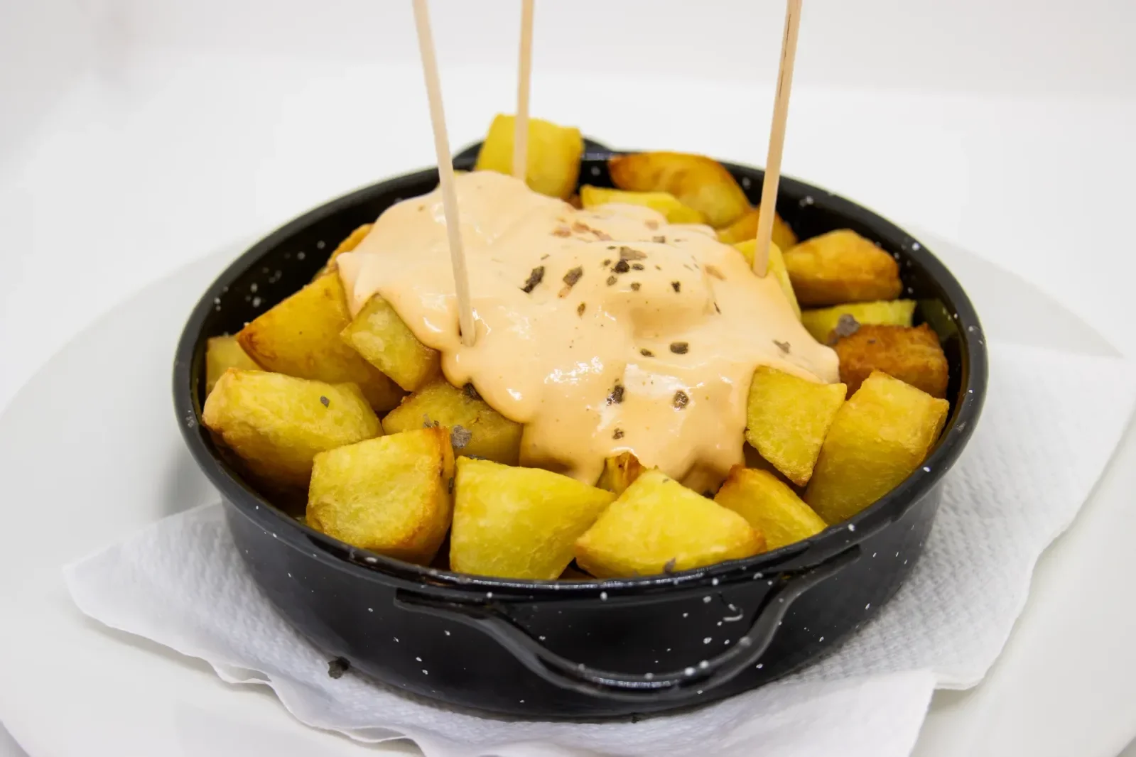 Patatas bravas con salsa en Agumas, restaurante de cocina mediterránea en Albanyà, Girona. Ideal para disfrutar en el corazón de la Alta Garrotxa.