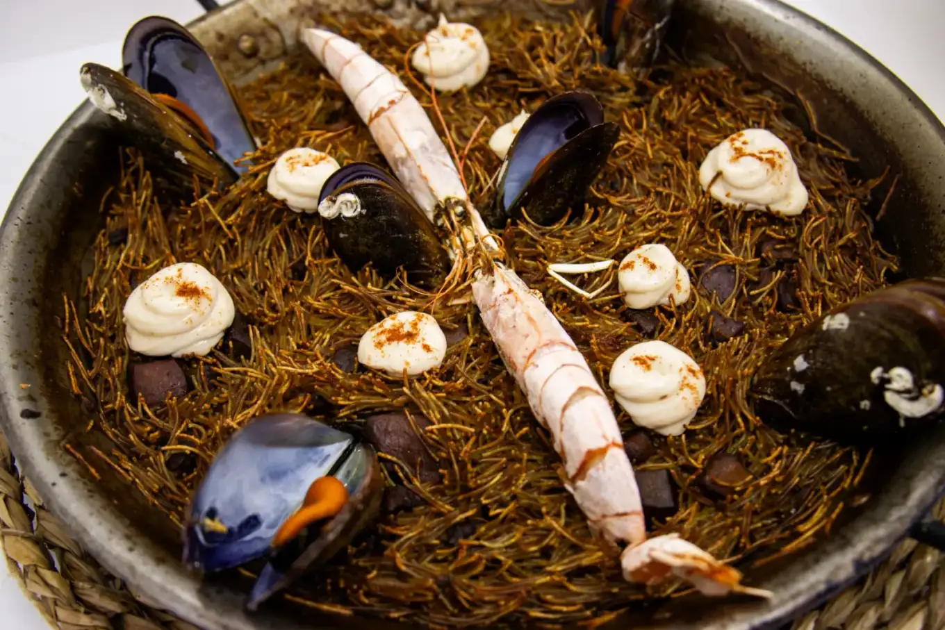 Fideuá de mariscos en Agumas, restaurante de cocina mediterránea en Albanyà, Girona. Disfruta de este plato en el corazón de la Alta Garrotxa.
