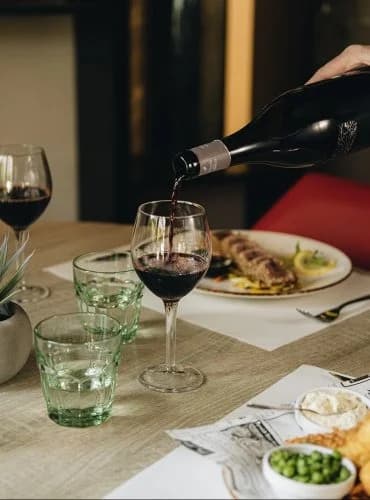 Servicio de vino tinto en Restaurant Ronda Figueres, acompañando un menú del día mediterráneo en Girona