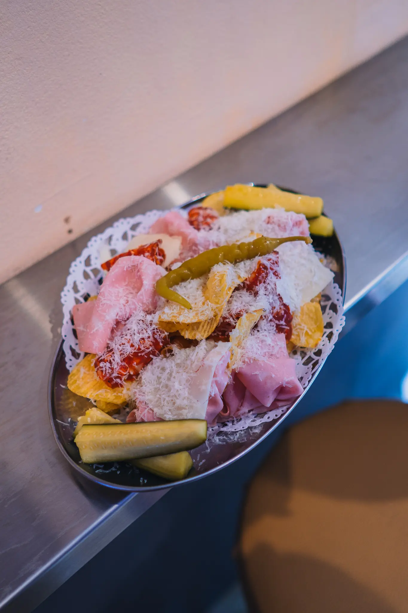 Fuente de picnic en Dreamboat Bar & Deli, Barcelona, con embutidos y encurtidos, ideal para disfrutar tapas en Sant Martí.