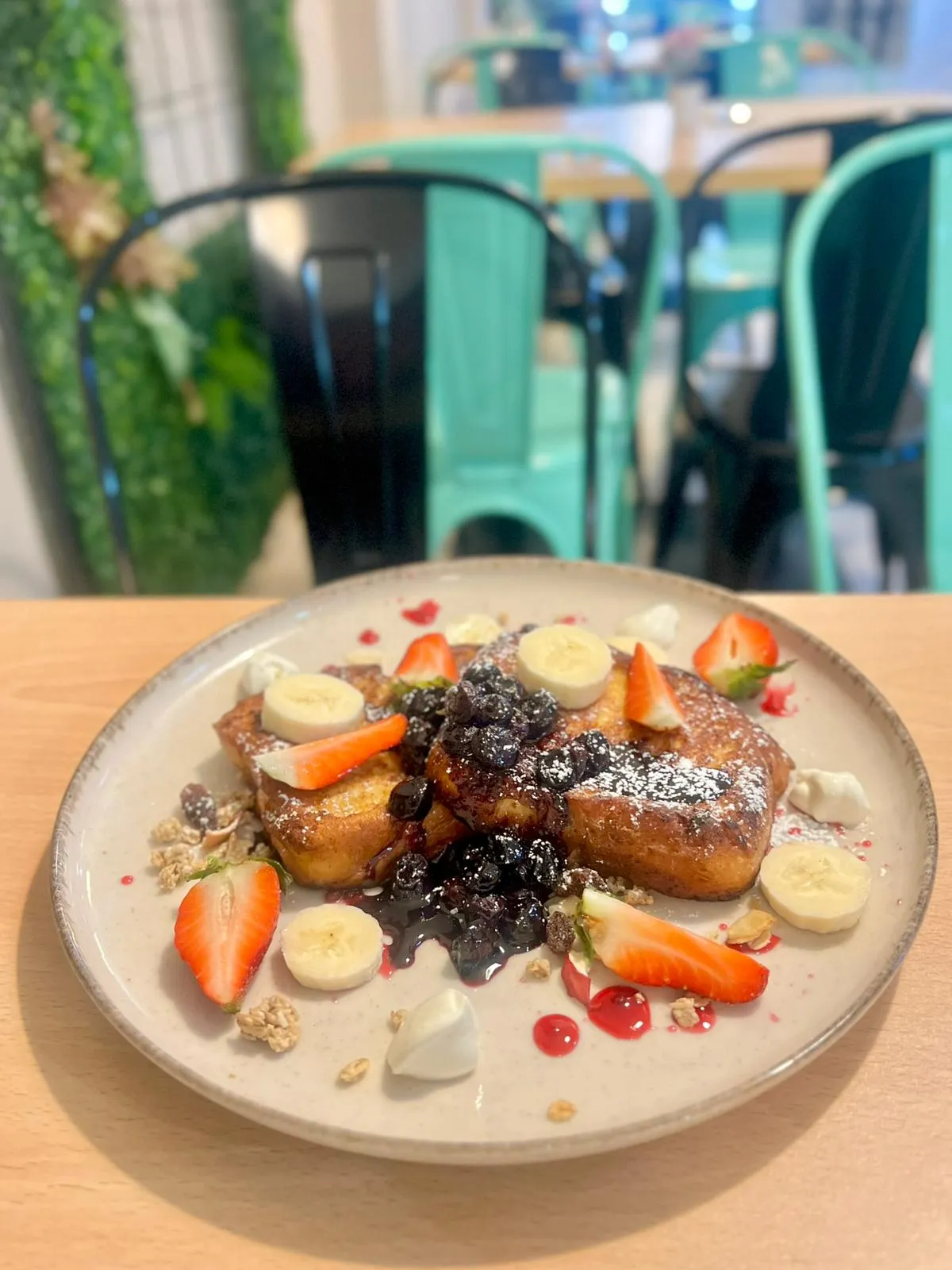 Tostadas francesas con frutas frescas servidas en Nomada Restaurant & Brunch, un lugar bohemio en el centro de Figueres, Girona, especializado en desayunos y brunch.