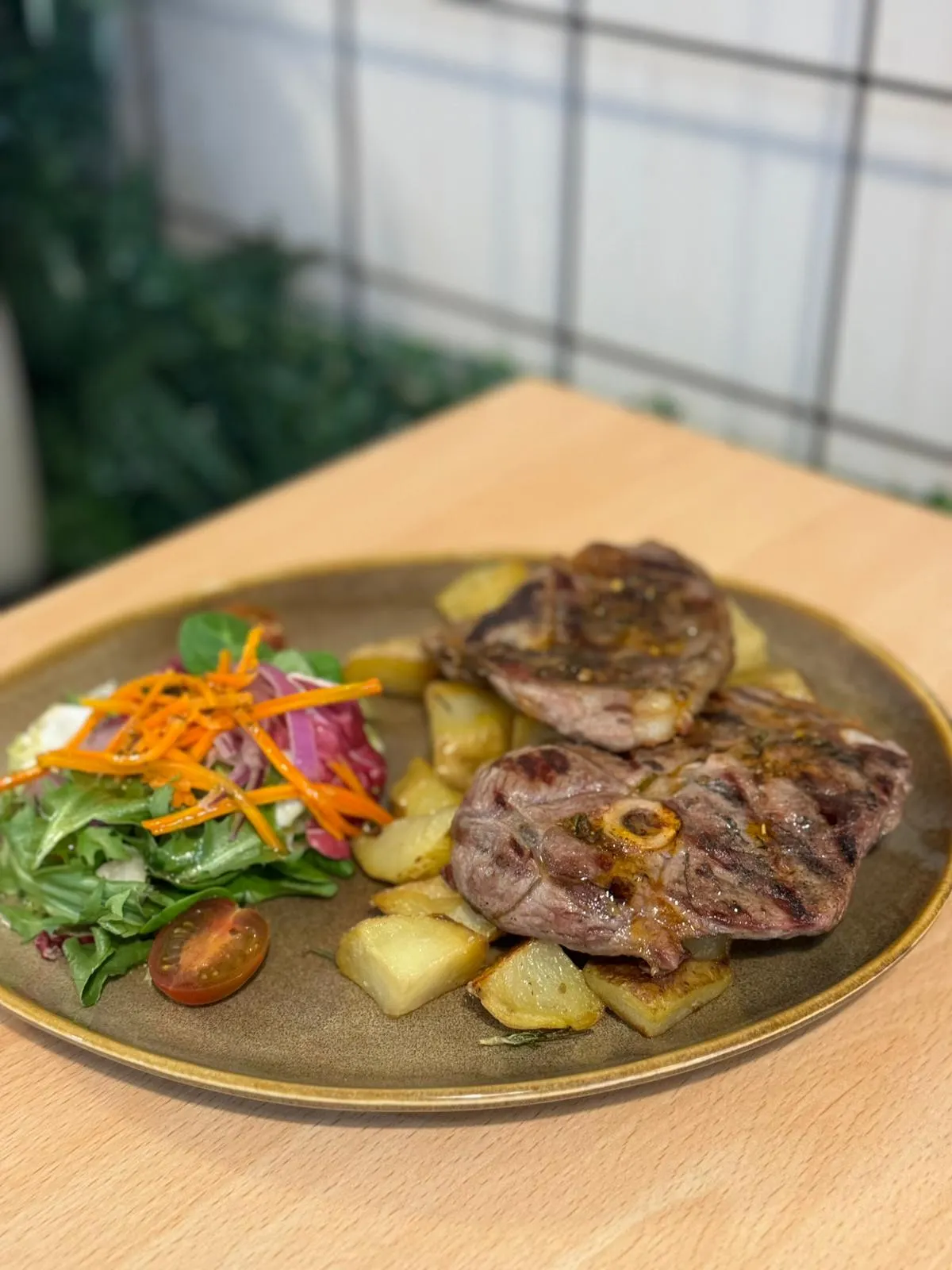 Cordero asado con patatas servido en Nomada Restaurant & Brunch, un lugar bohemio en el centro de Figueres, ideal para desayunos y brunch.