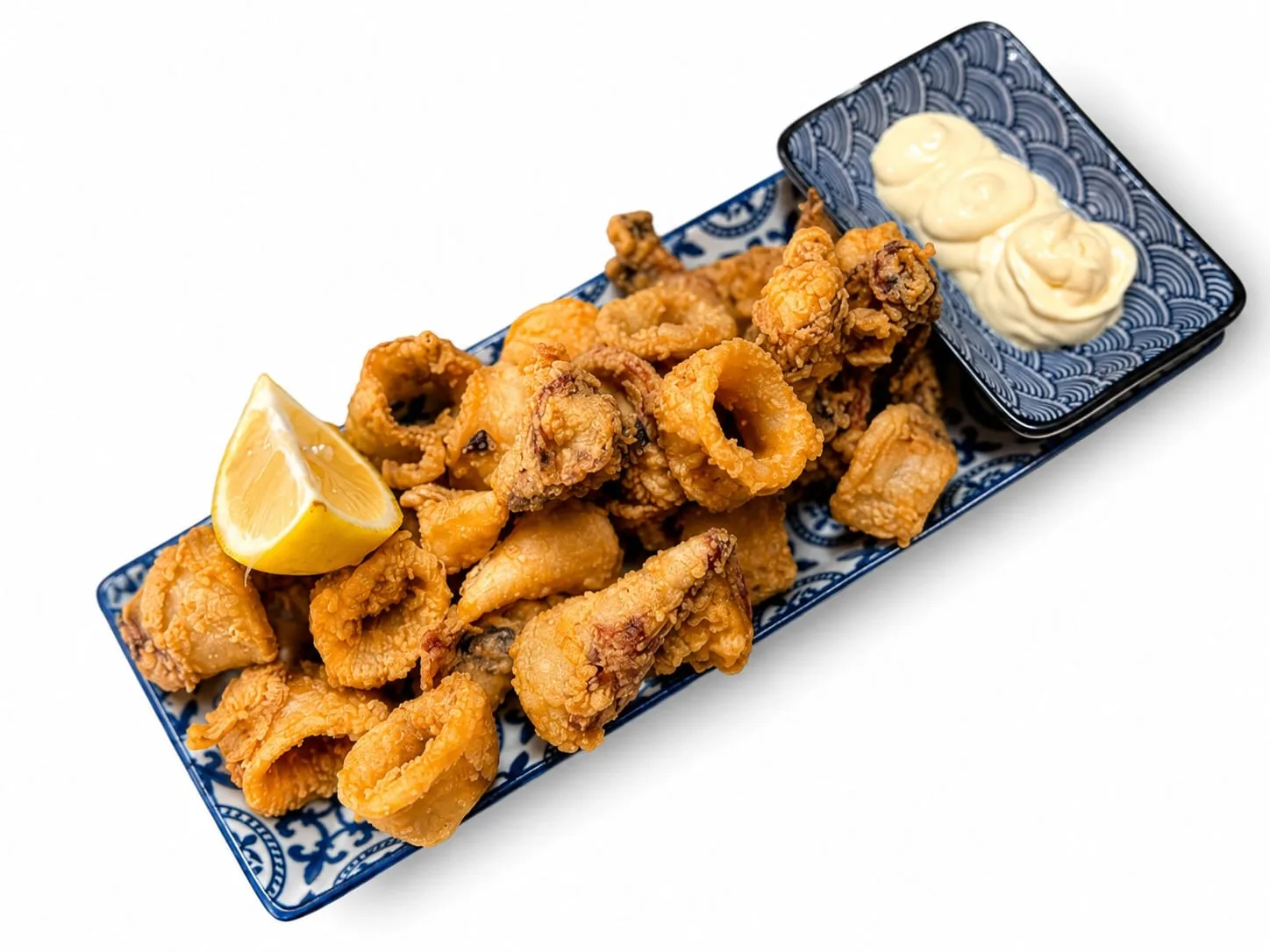 Nuestros calamares a la andaluza con mayo cítrica y limón en bandeja rectangular en Nomada Restaurant & Brunch, Figueres