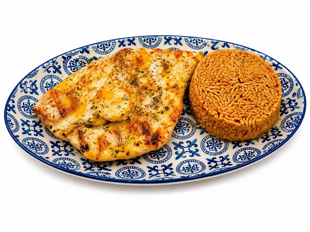 Pechuga de pollo a la plancha con hierbas y guarnición de arroz servida en Nomada Restaurant & Brunch en Figueres, Girona