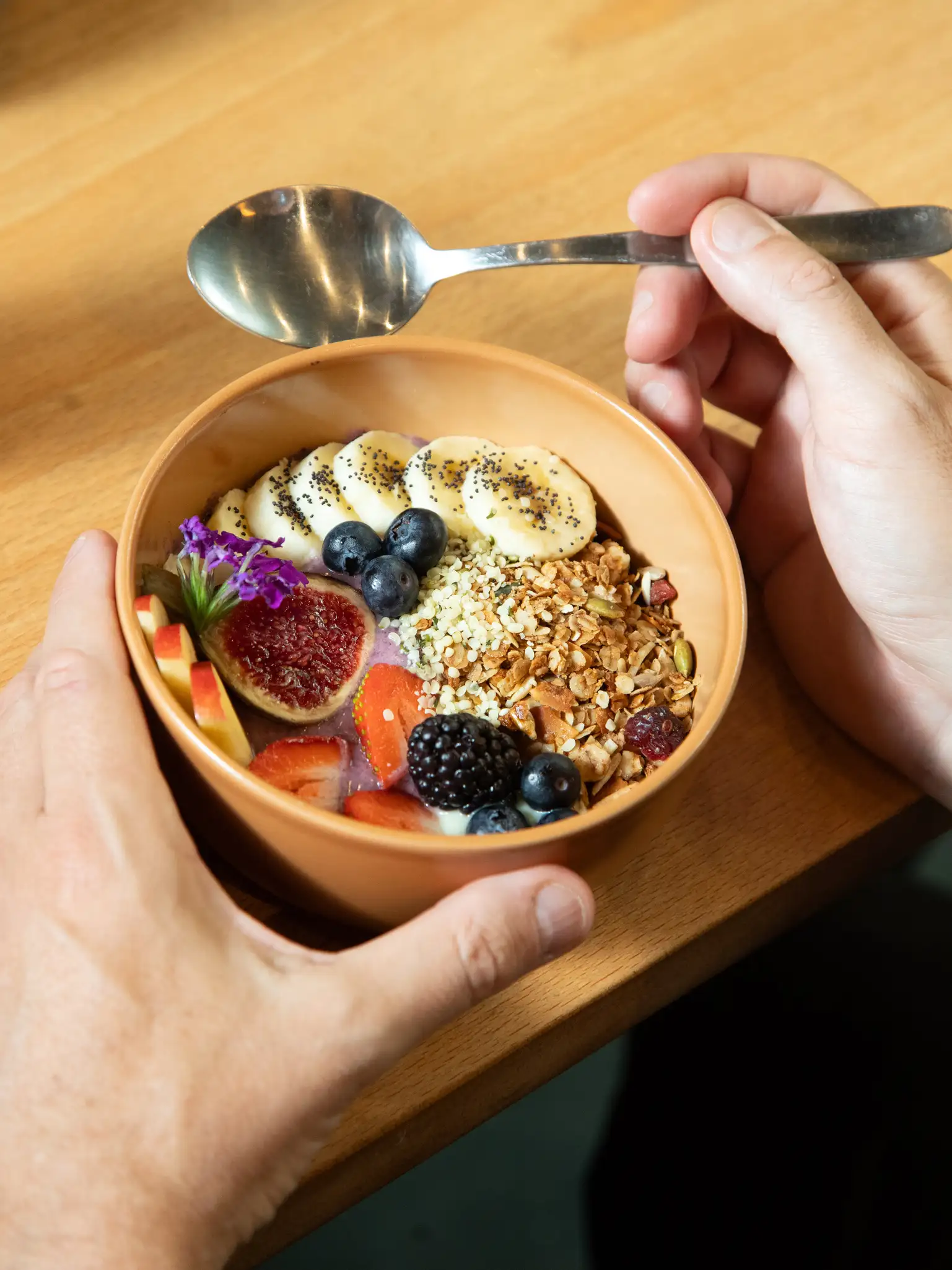 Superbol de granola en Morgentau, restaurante de brunch vegano en Sant Martí, Barcelona, con frutas frescas y semillas.