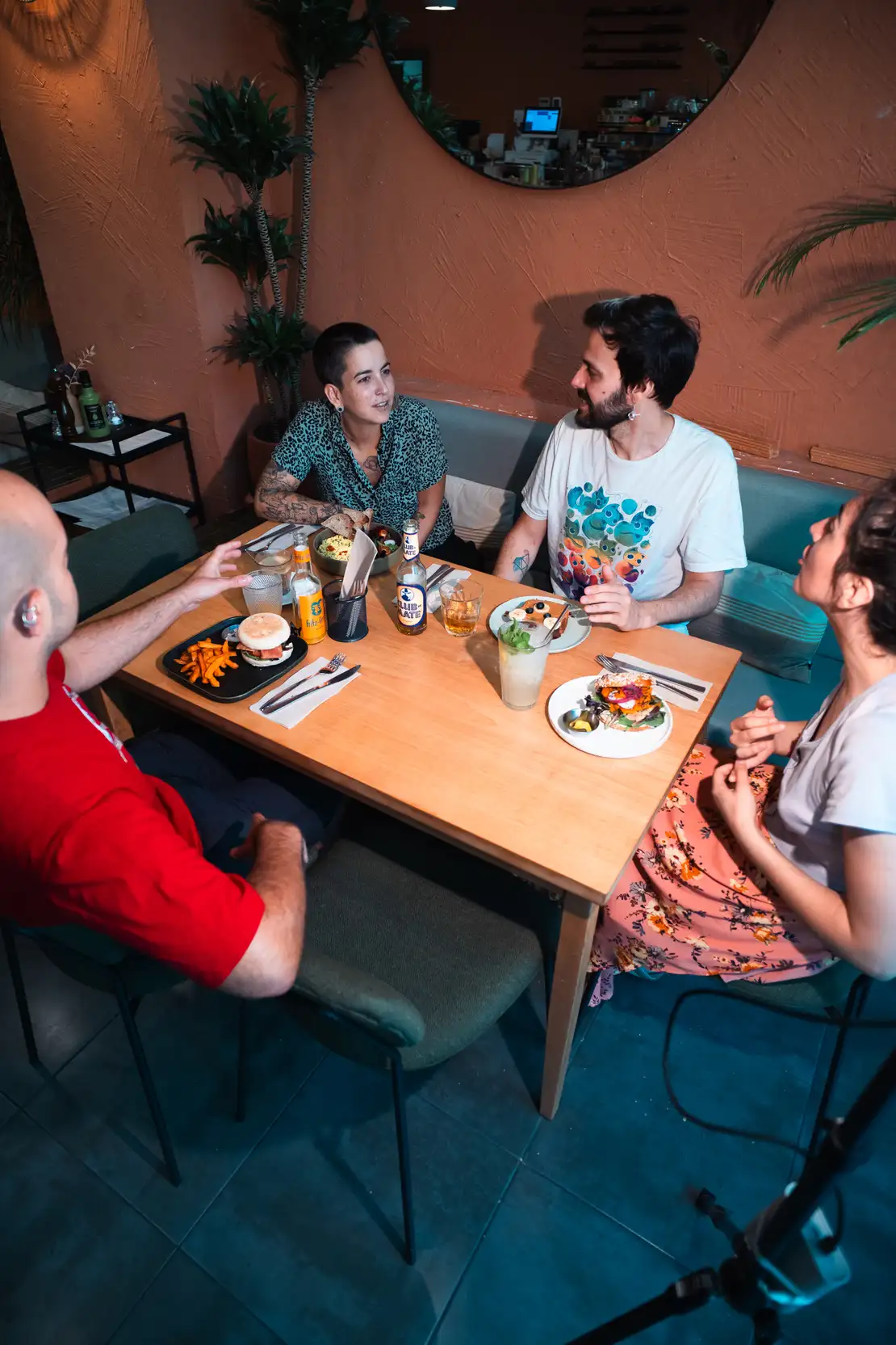Interior del restaurante Morgentau en Sant Martí, Barcelona, mostrando a clientes disfrutando de un brunch vegano con platos como el bol de ensalada de quinoa y el muffin BLT.