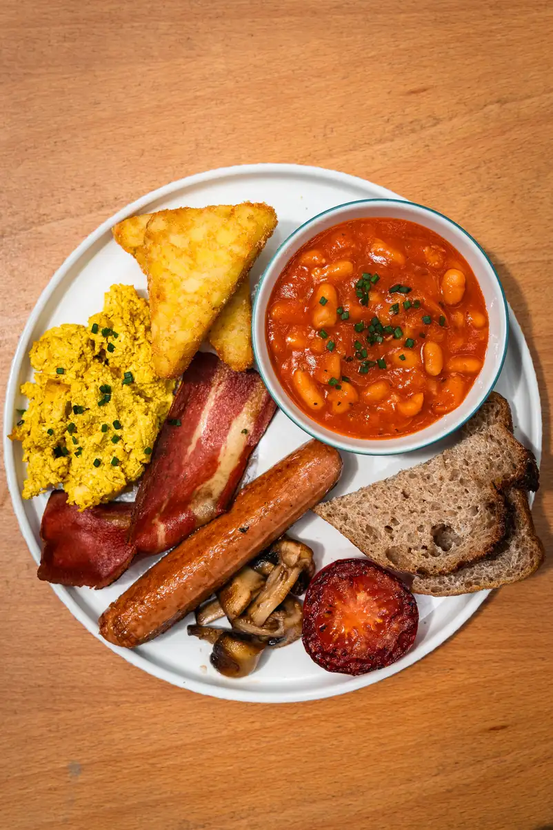 Esmorzar anglès complet en Morgentau, brunch vegano en Sant Martí, Barcelona, con tofu, salchicha vegetal y tostadas.