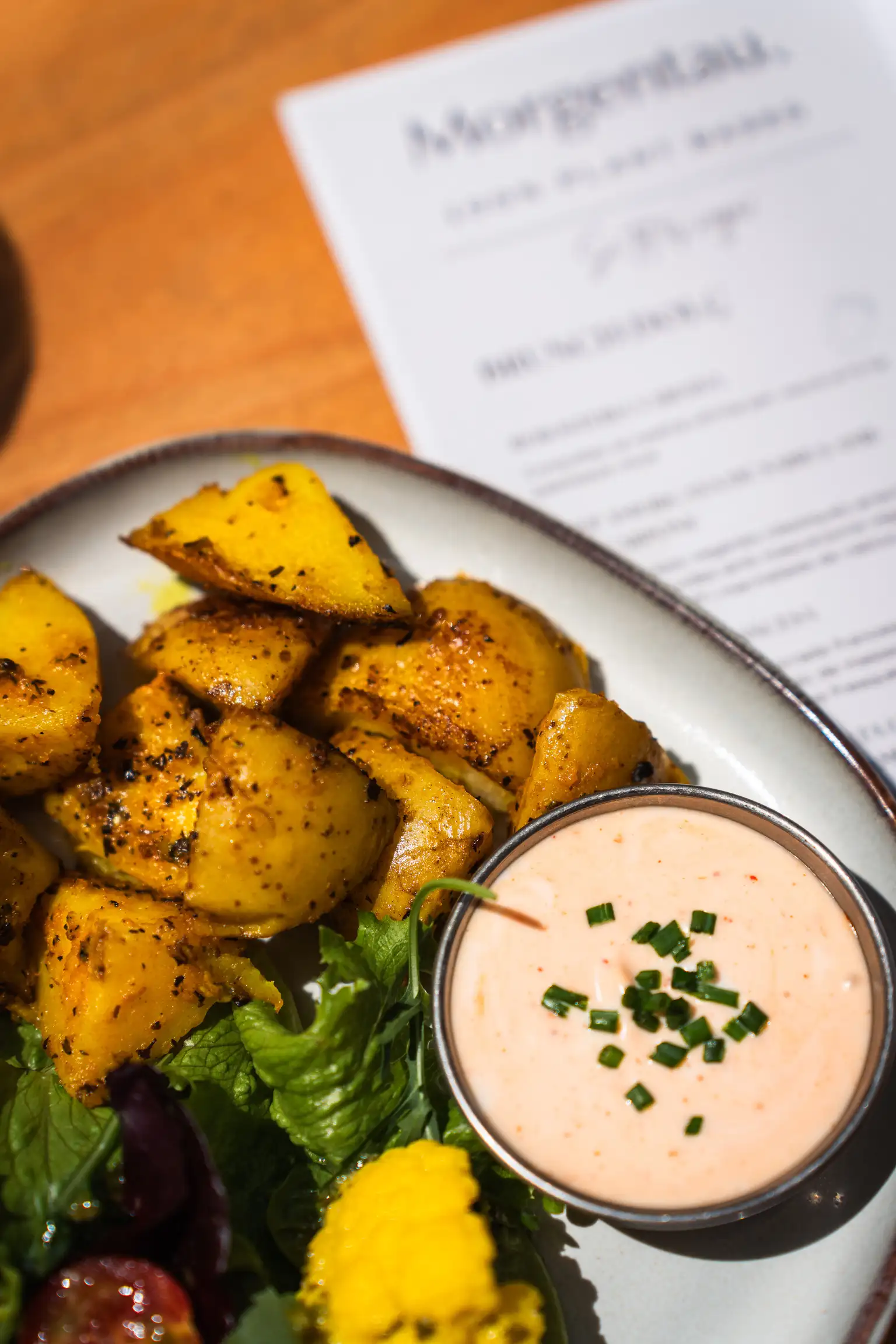 Plato de patatas especiadas con salsa en Morgentau, restaurante vegano en Sant Martí, Barcelona, ideal para brunch y menú del día.