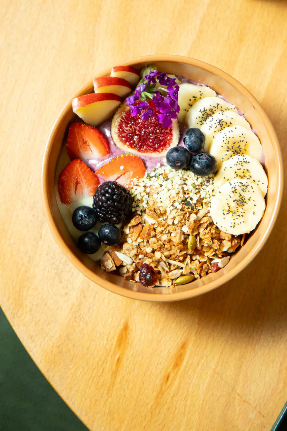 Super bol de granola en Morgentau, restaurante brunch vegano en Sant Martí, Barcelona, con frutas frescas y semillas.