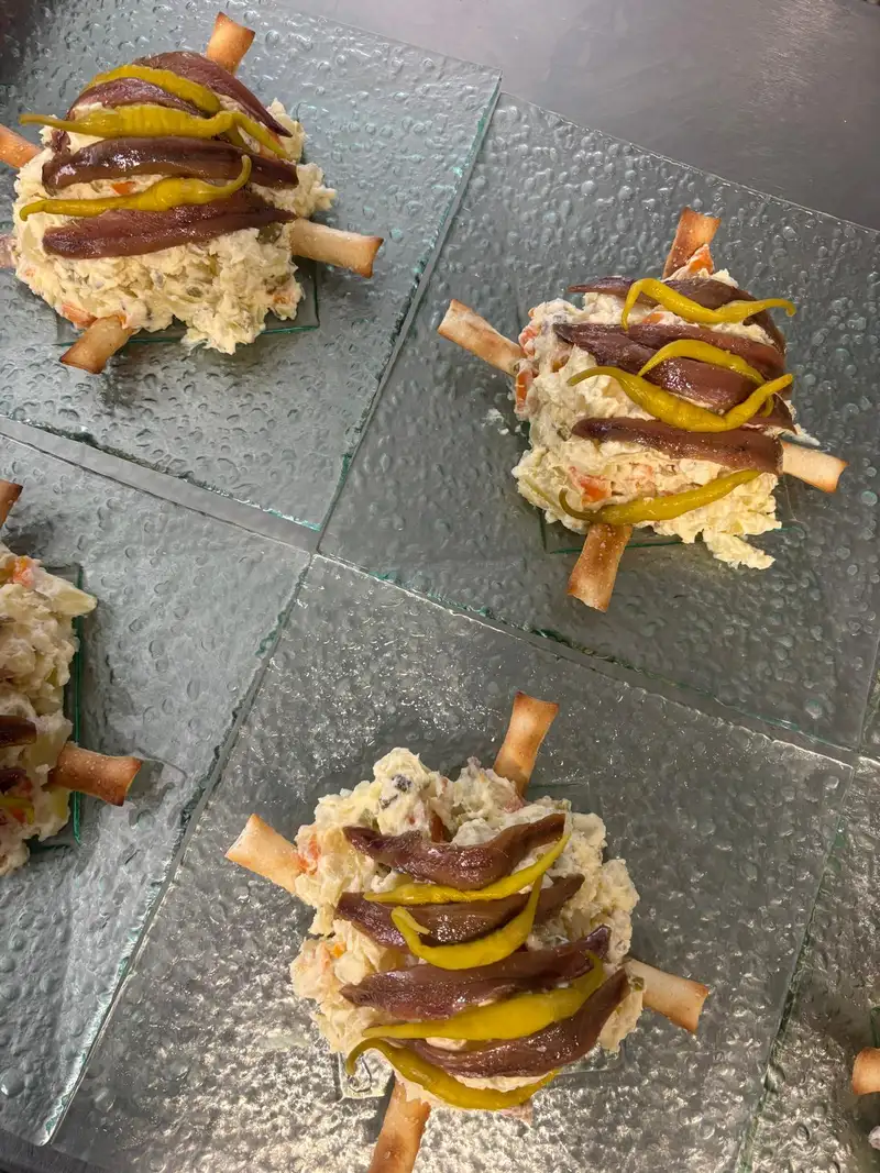 Ensaladilla d'anxova en El Pati de Vilabertran, restaurante con terraza al aire libre cerca de Figueres, especializado en carne a la brasa.