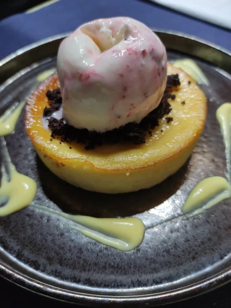 Delicioso postre de Restaurant Navili en L'Escala, con helado sobre bizcocho, representando la cocina mediterránea.