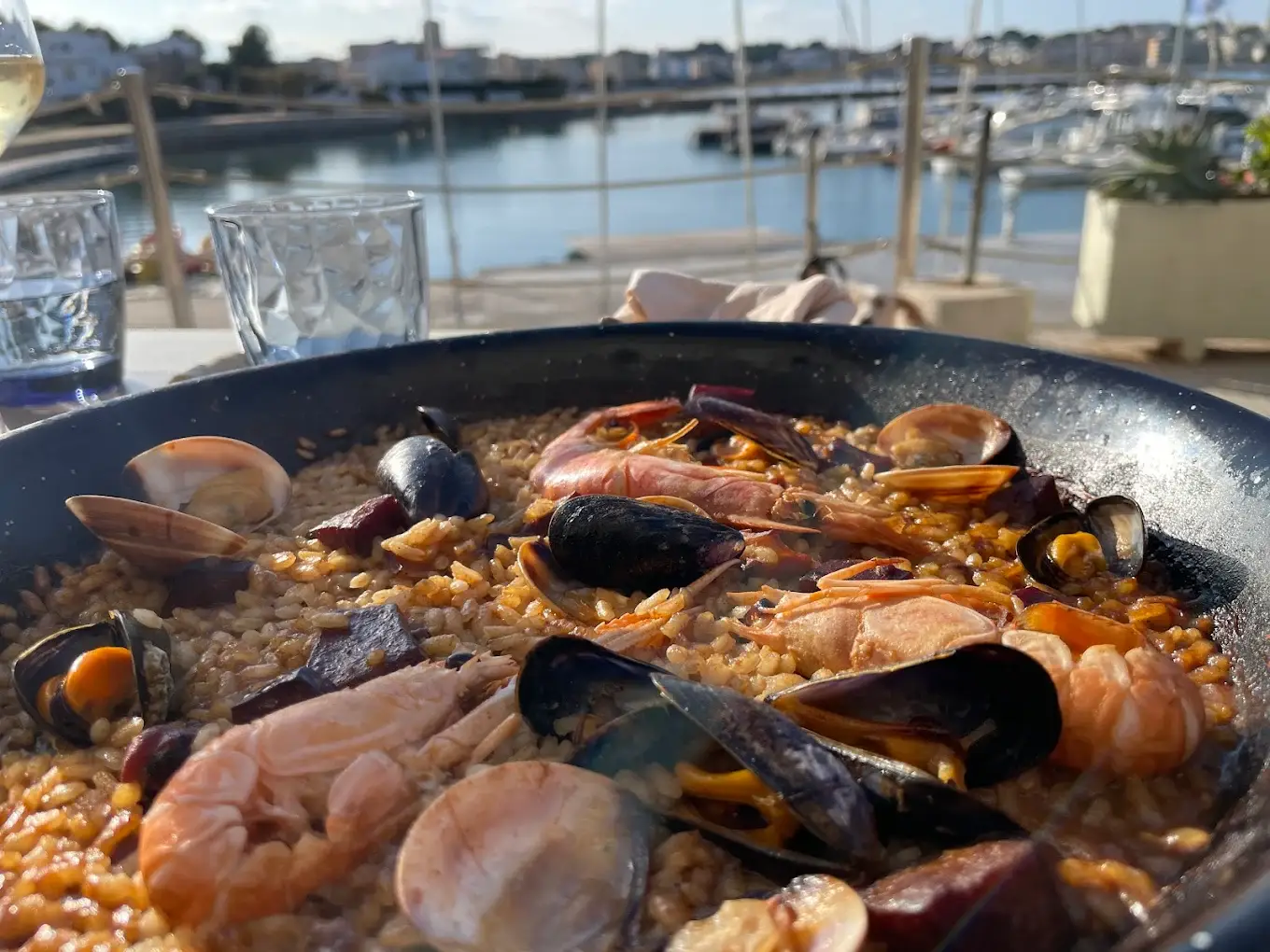 Paella de marisco en Restaurant Navili, cocina mediterránea en L'Escala con vistas al puerto.