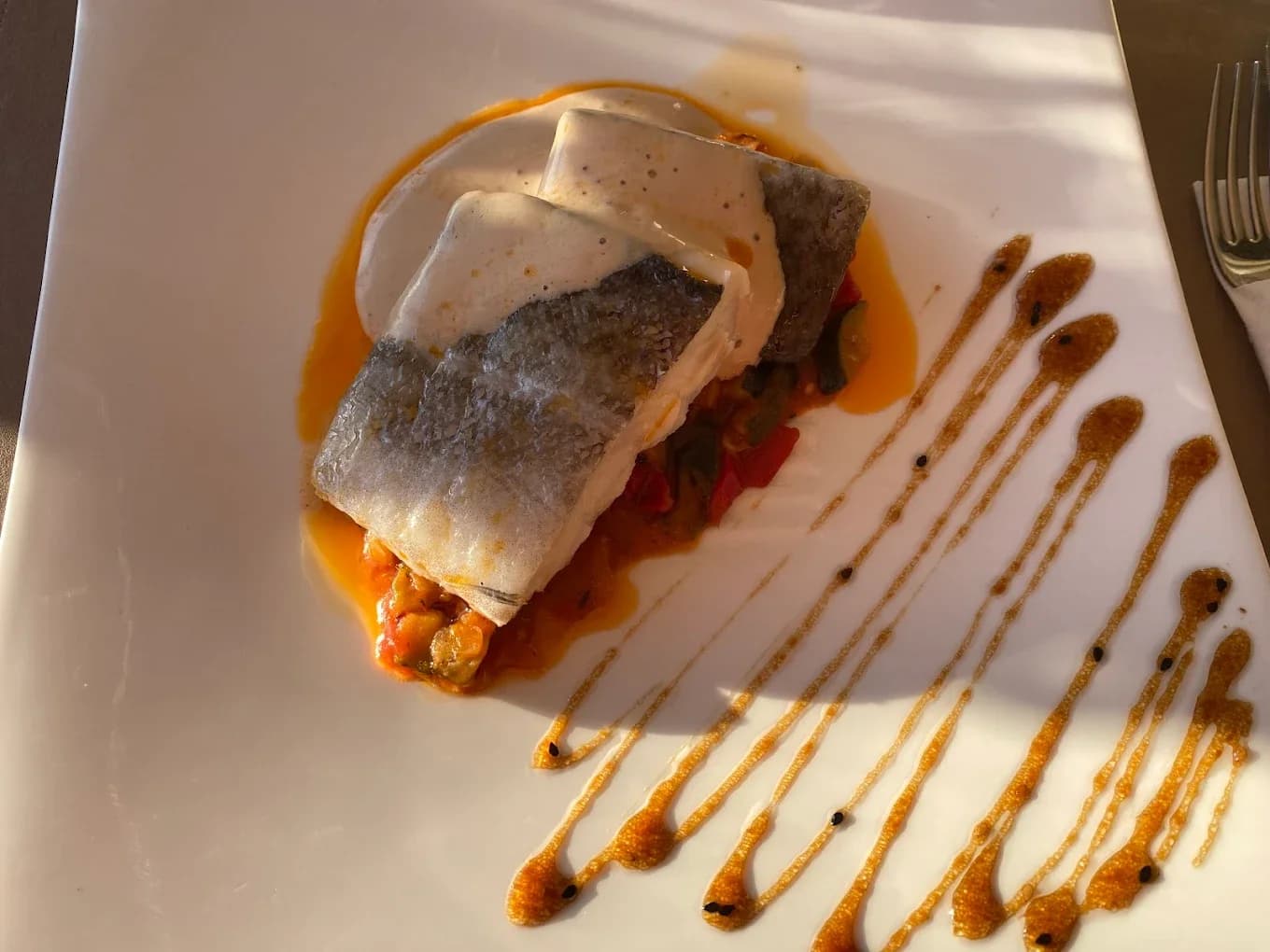 Bacalao con salsa en Restaurant Navili, cocina mediterránea en L'Escala, Girona. Disfruta de especialidades marineras con vistas al puerto.