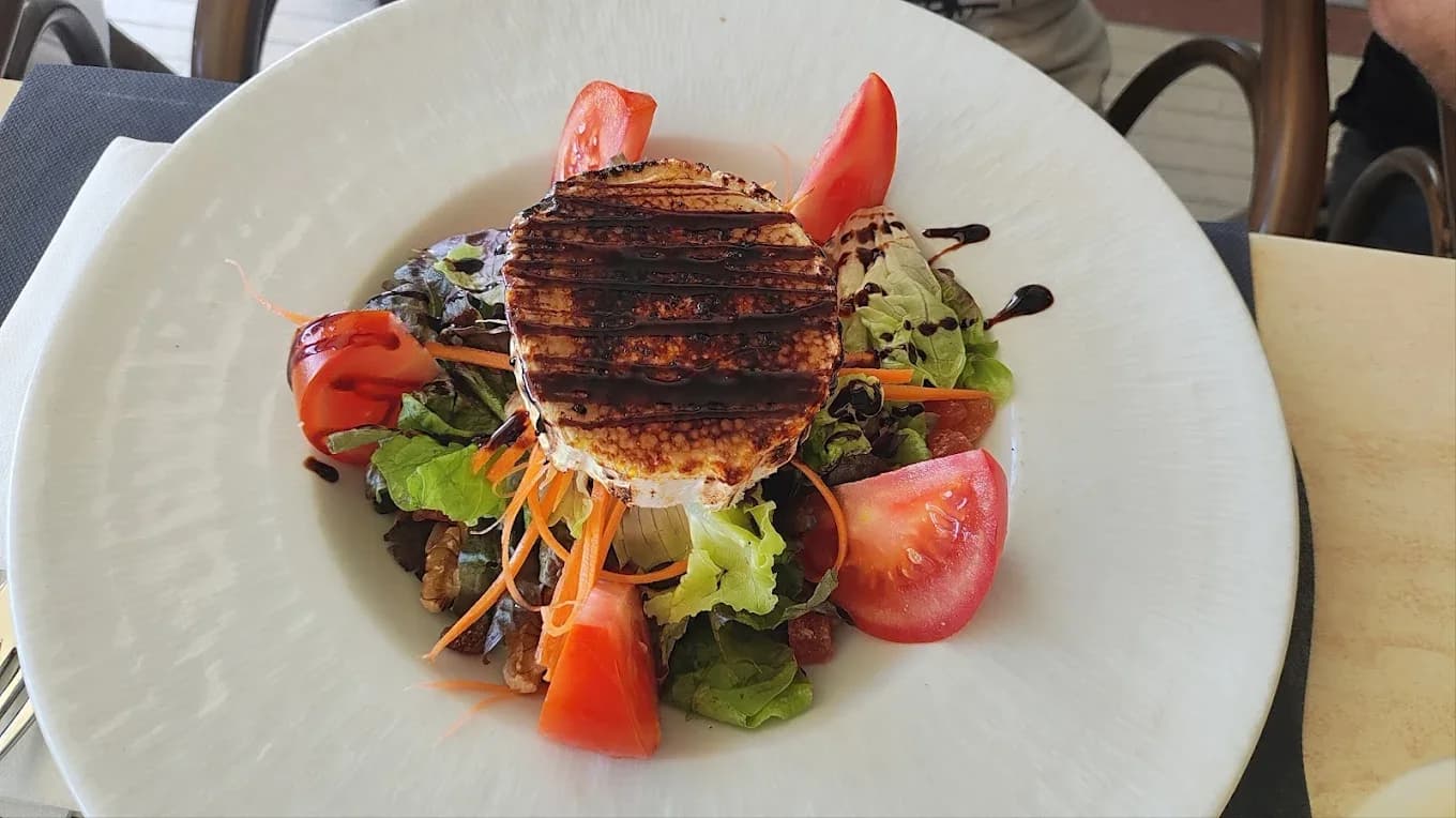 Ensalada con queso de cabra caramelizado en Restaurant Navili, L'Escala. Disfruta de la cocina mediterránea con vistas al puerto.