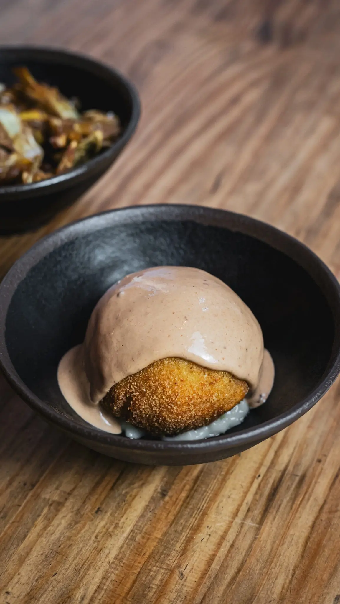 Croqueta con salsa especial en Amélie Restaurant, tapas de autor en Plaça de la Vila de Gràcia, Barcelona.