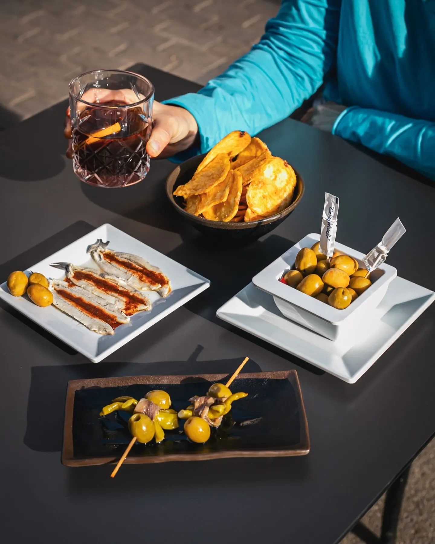 Tapas de autor en Amélie Restaurant, ubicado en Plaça de la Vila de Gràcia, Barcelona. Disfruta de aceitunas, anchoas y patatas en nuestra terraza mediterránea.