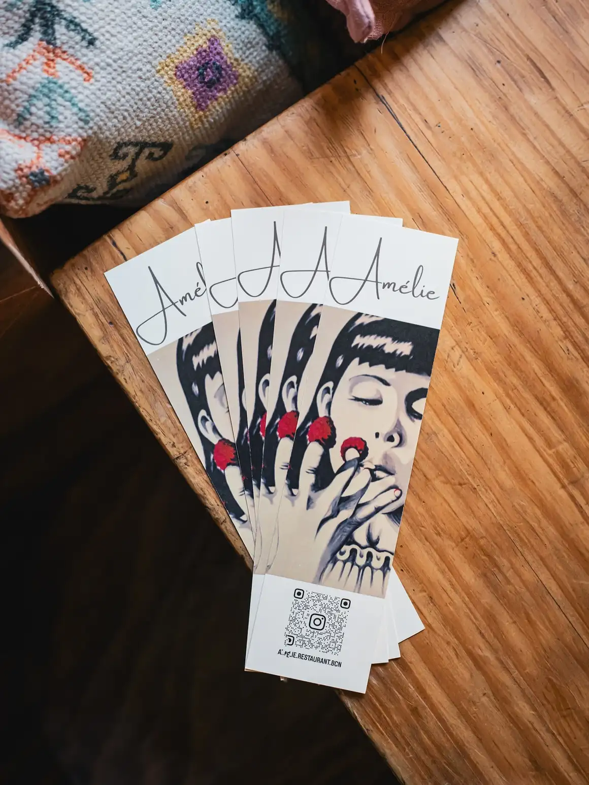 Tarjetas de presentación del Amélie Restaurant en Plaça de la Vila de Gràcia, Barcelona, destacando su estilo único y mediterráneo.