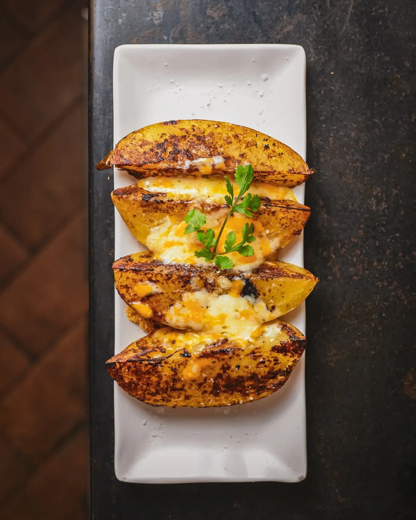 Patatas asadas con queso en Amélie Restaurant, tapas de autor en Plaça de la Vila de Gràcia, Barcelona. Disfruta de nuestra cocina mediterránea.