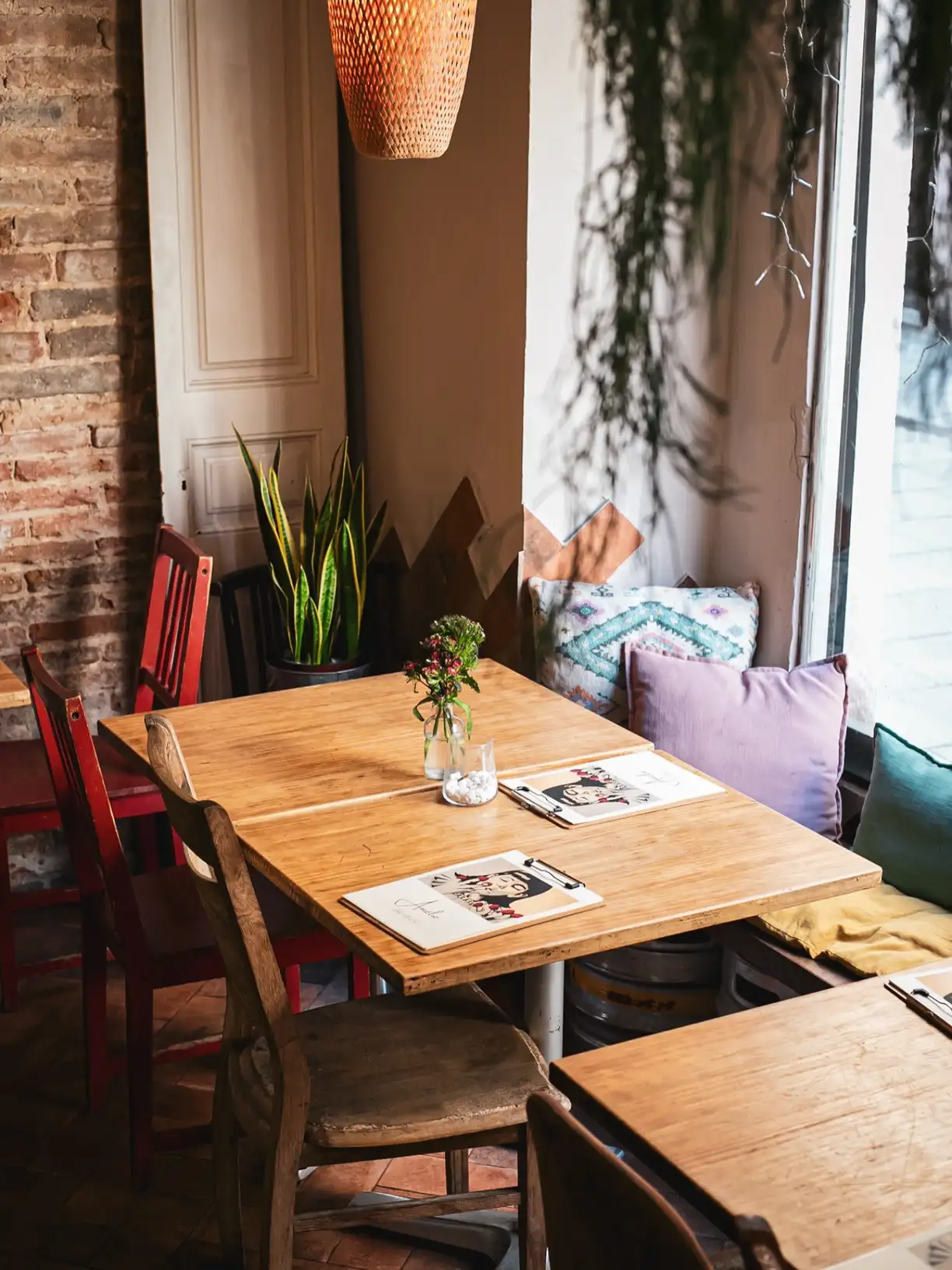 Interior acogedor del Amélie Restaurant en Plaça de la Vila de Gràcia, Barcelona, con decoración mediterránea y ambiente cálido.