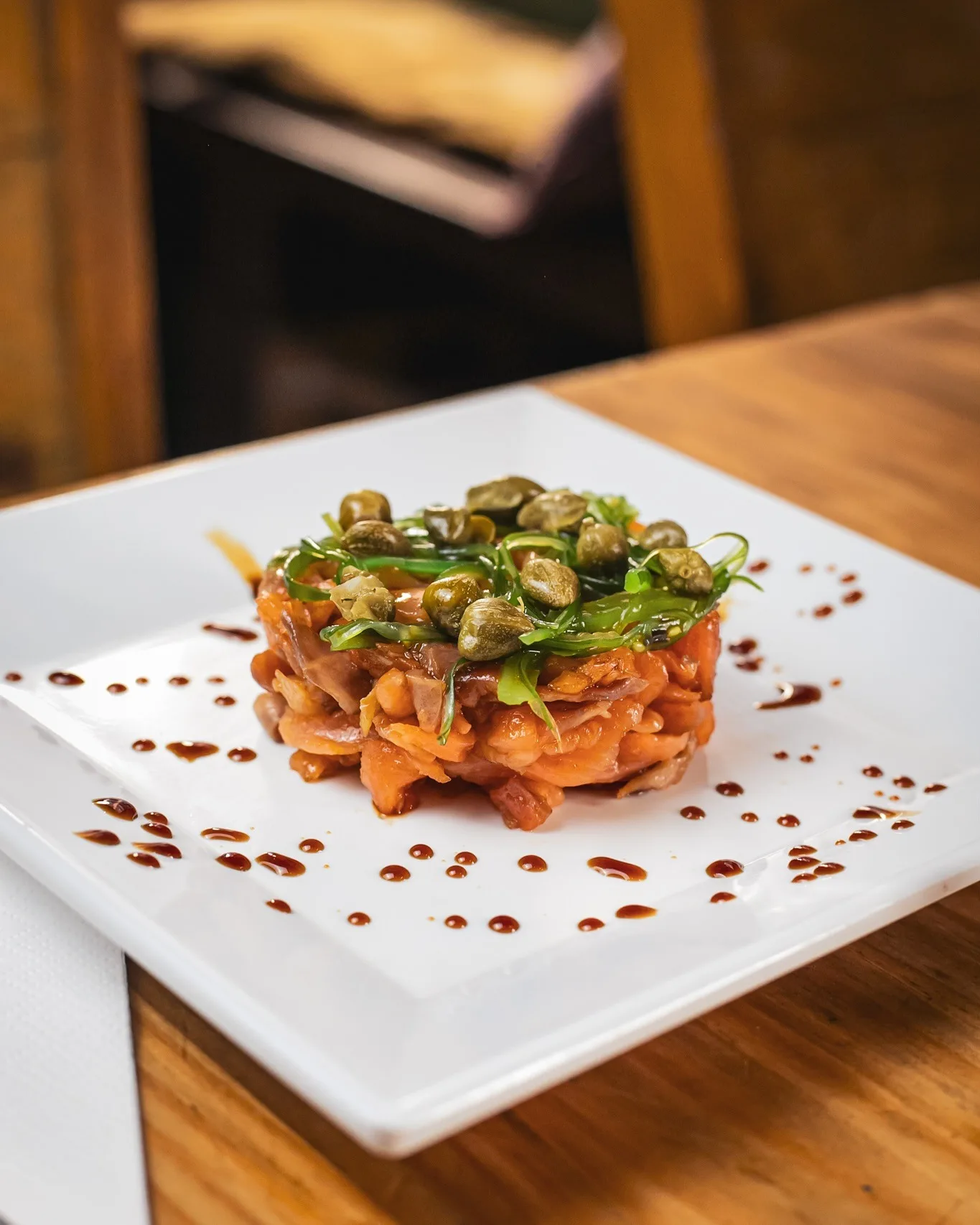 Tartar de salmón con alcaparras en Amélie Restaurant, tapas de autor en Plaça de la Vila de Gràcia, Barcelona.
