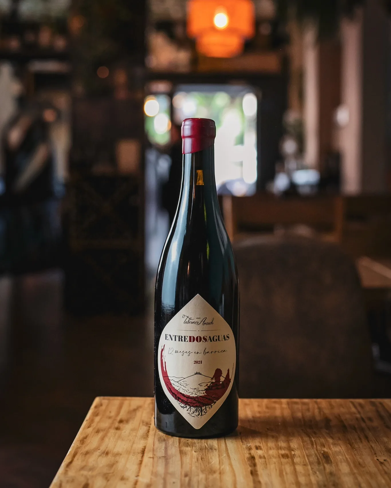 Botella de vino en Amélie Restaurant, ubicado en Plaça de la Vila de Gràcia, Barcelona. Disfruta de nuestra selección de vinos en un ambiente mediterráneo.