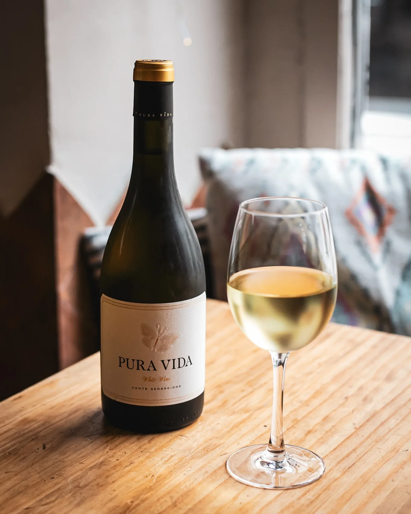 Botella de vino blanco Pura Vida servida en Amélie Restaurant, especializado en cocina mediterránea en Plaça de la Vila de Gràcia, Barcelona.