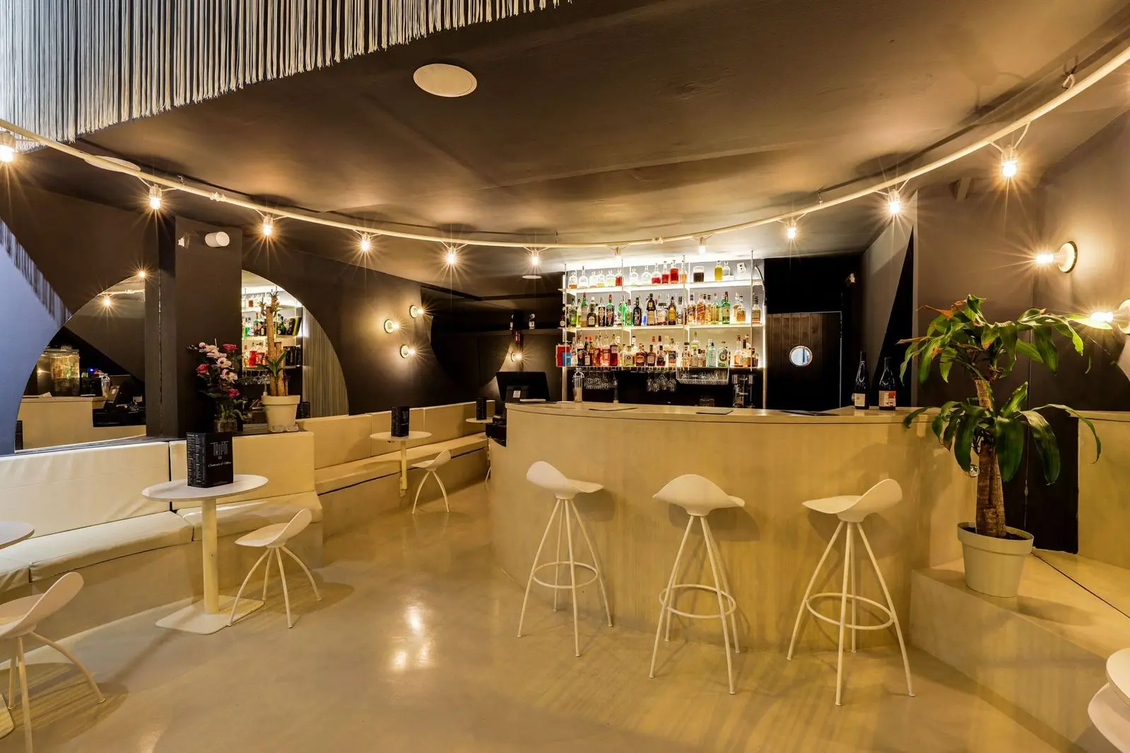 Interior sofisticado y relajado del Tripti Bar en Poblenou, Barcelona, ideal para disfrutar de coctelería de autor y tapas indias.