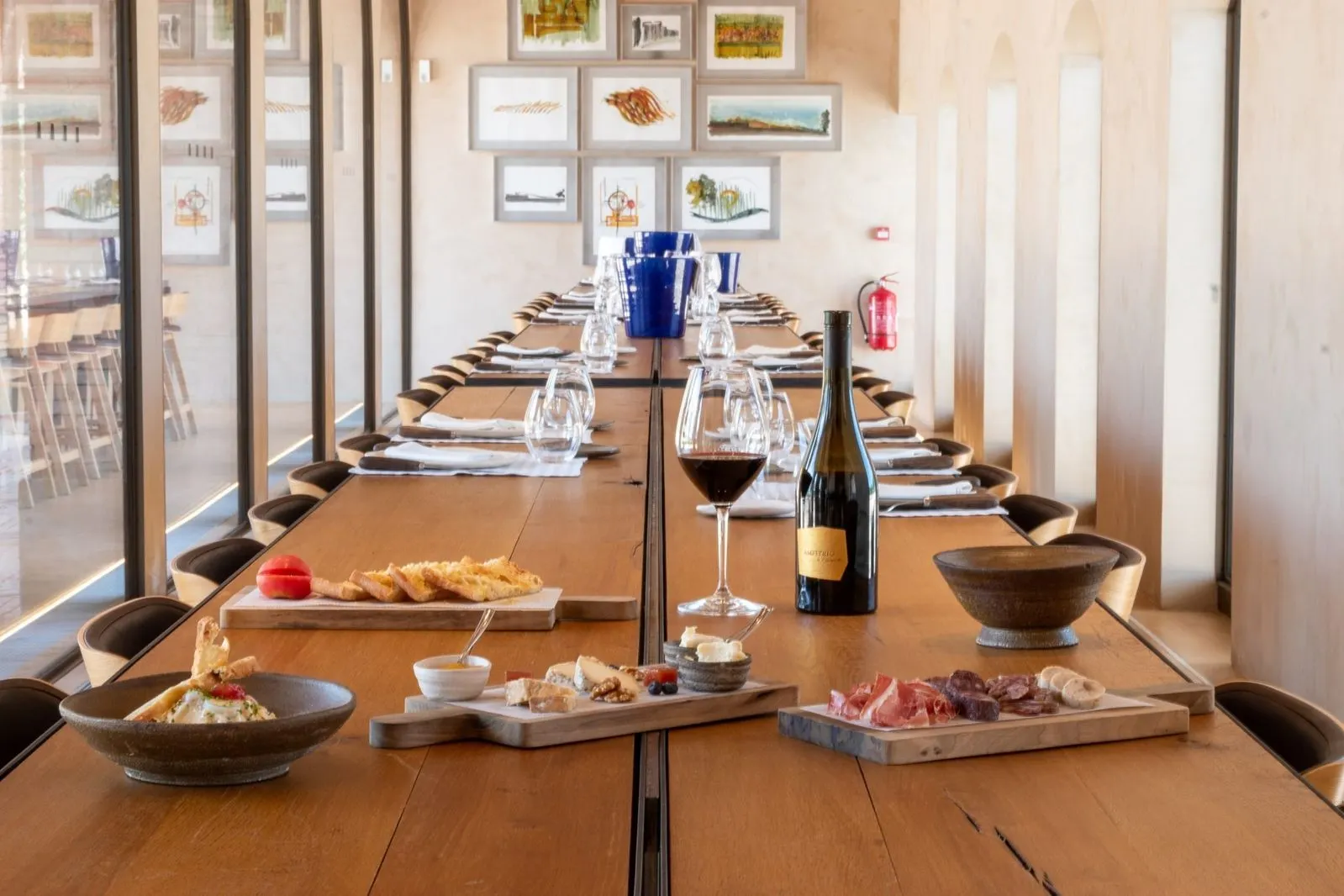 Mesa de degustación en Celler 1923, restaurante mediterráneo en Peralada, con embutidos y vinos locales en un ambiente elegante.