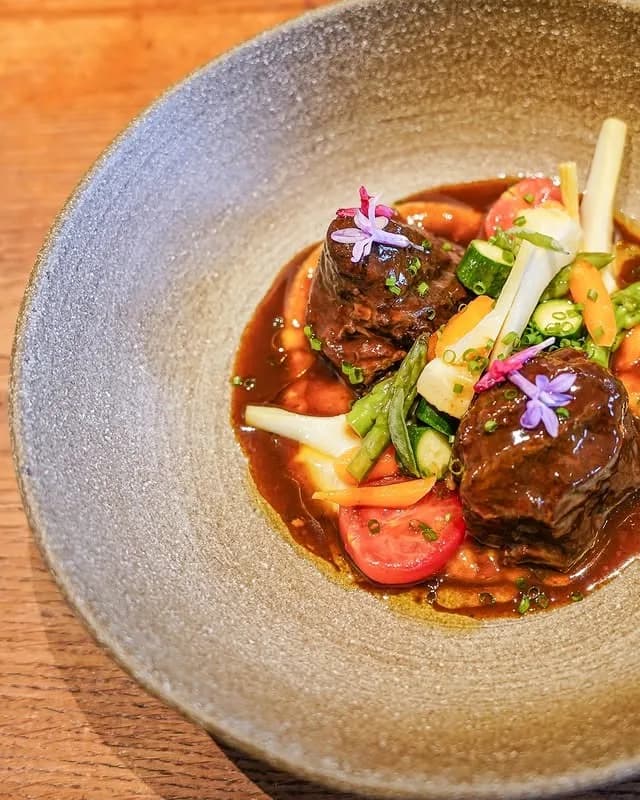 Estofado de ternera con verduras en Celler 1923, restaurante mediterráneo en Peralada, Girona. Disfruta de la cocina catalana en el corazón de la Bodega Perelada.