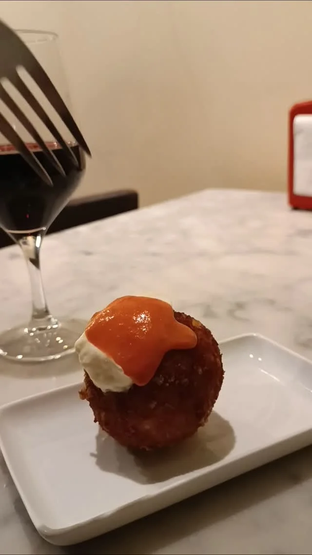 Tapeta de formatge en Bar Bodega Fermín, restaurante mediterráneo en Barcelona, acompañada de una copa de vino tinto.