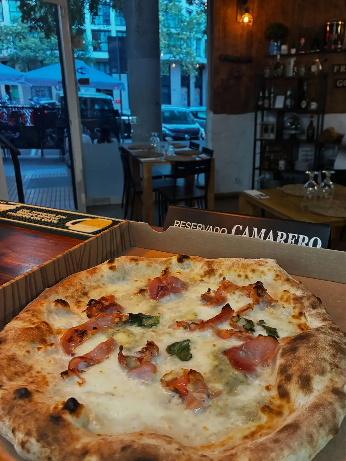 Pizza con jamón y albahaca en Ristorante Il Capriccio Napoletano, auténtica cocina italiana en Sant Martí, Barcelona.