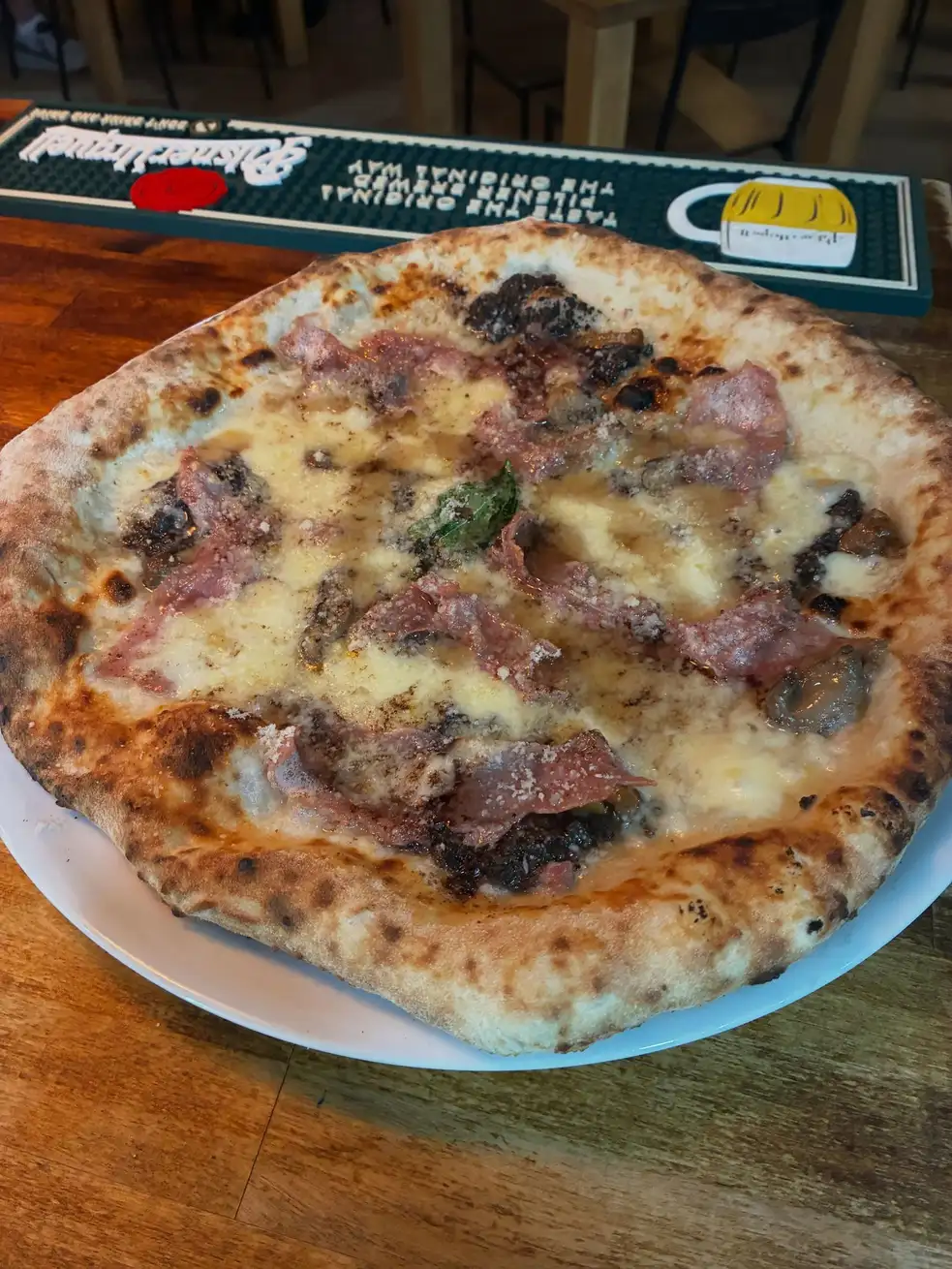 Deliciosa pizza con jamón y champiñones en Ristorante Il Capriccio Napoletano, auténtica cocina italiana en Sant Martí, Barcelona