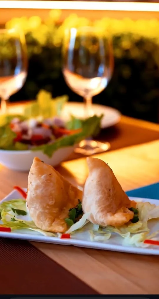 Dos Veg Samosa crujientes sobre lechuga en la mesa del restaurante Royal King indian cuisine en Barcelona