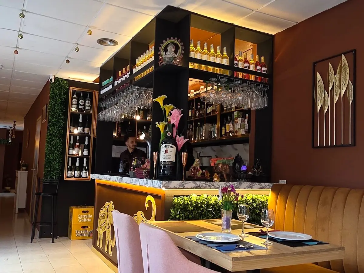 Barra interior iluminada con botellas y copas en Royal king indian cuisine, restaurante de cocina india en Sant Martí, Barcelona