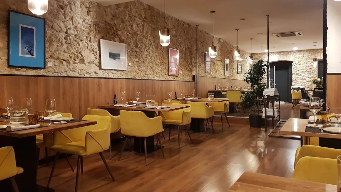 comedor de restaurante con sillas amarillas, paredes de piedra y ambiente cálidojpg